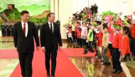 French President Emmanuel Macron (2nd L) walks with Chinese President Xi Jinping as they are greeted by children during a welcome ceremony at the Great Hall of the People in Beijing on January 9, 2018. AFP / Ludovic Marin