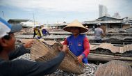 Daily paid workers sort dried fish during the drying process at Muara Baru district in Jakarta, Indonesia, January 8, 2018. Reuters/Beawiharta