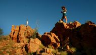 File photo of two tourists watch the setting sun from atop a rocky outcrop in the West MacDonnell Ranges along the Larapinta Trail about 110 kilometres (66 miles) west of the central Australian town of Alice Springs April 18, 2004. REUTERS/Tim Wimborne/Fi