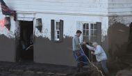 An older man is hekled as he tries to enter his mud-damaged home, January 10, 2018 in Montecito, California.  AFP / Robyn Beck
