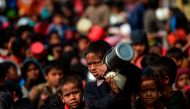 A Rohingya Muslim refugee waits with others for food aid at Thankhali refugee camp in Bangladesh's Ukhia district on January 12, 2018. / AFP / Munir UZ ZAMAN