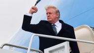 US President Donald Trump gestures as he boards Airforce One at Joint Base Andrews, Maryland on January 12, 2018, for a weekend trip to Mar-a-Lago. AFP / Nicholas Kamm