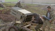 Two men prepare a multi-barrel rocket launcher within the clashes between armed opposition group Tahrir al-Sham and Assad Regime forces around the Abu Al-Duhur Military Airbase in a de-escalation zone in Idlib, Syria on January 13, 2018.Rasheed Hababa - A