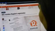 This photo illustration shows a woman reading the website of online news portal Rappler in Manila on January 15, 2018. AFP / TED ALJIBE