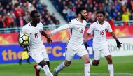 Qatari striker Almoez Ali carries the ball as he celebrates with team-mates  Ahmad Moein (centre) and  Hashim Ali (right) after scoring his first goal against China during their AFC U-23 Asian Cup match played in Changzhou, China on Monday.