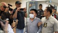 A handout photo made available by Freeland, a frontline counter-trafficking organization, shows wildlife trafficking suspected Bach Van Minh, also known as Boonchai Bach (C), being escorted by Thai police officers at the Suvarnabhumi Airport's police stat