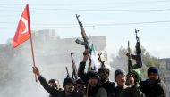 Members of Free Syrian Army (Turkey-backed) fighters tour with their guns as they hold Turkish and their flag in the Syria city of Azez, near the Syrian-Turkish border, 19 January 2018. EPA/HASAN KIRMIZITAS