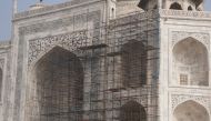 This photograph taken on January 3, 2018 shows tourists visiting the Taj Mahal near scaffolding installed for the conservation work at the monument in the Indian city of Agra. / AFP / DOMINIQUE FAGET 