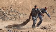 FILE PHOTO: Iraqi forces pull a body out from a mass grave they discovered in the Hamam al-Alil area on November 7, 2016. (AFP / Ahmad Al-Rubaye) 