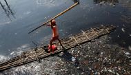 FILE PHOTO: A government worker uses a raft to gather plastic and other debris for collection and disposal from the Sekretaris River in Jakarta, Indonesia, June 7, 2017. Reuters/Darren Whiteside
