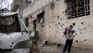 A Syrian child plays with a cardboard gun in the rebel-held town of Harasta, in the Eastern Ghouta region on the outskirts of Damascus on January 25, 2018. / AFP / ABDULMONAM EASSA