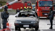 Afghan police officers keep watch while a man drives his damaged car at the site of a car bomb attack in kabul, Afghanistan January 27, 2018. REUTERS/Omar Sobhani	