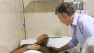 Colombian President Juan Manuel Santos (R) visits an injured police officer at the hospital in Barranquilla, on January 27, 2018. / AFP / JOSE TORRES