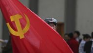 A participant waves a Chinese Communist Party flag as he waits backstage before his performance at a line dancing competition in Kunming Yunnan province, January 31, 2015 (Reuters) 
