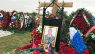 A flag of the separatist self-proclaimed Donetsk People's Republic is seen near a portrait of Russian General Valery Asapov on his grave at a military cemetery near Moscow, Russia October 3, 2017. Reuters/Maria Tsvetkova