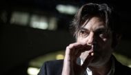 Jonathann Daval's lawyer, Randall Schwerdorffer, smokes as he poses during a photo session, in Besancon on January 30, 2018, after Daval has admitted to killing his wife, Alexia Daval, by accident. AFP / Sebastien Bozon