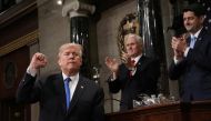 US President Donald J. Trump (L) gestures at the podium in front of US Vice President Mike Pence (L) and Speaker of the House US Rep. Paul Ryan (R-WI) during his first State of the Union address to a joint session of Congress inside the House Chamber on C
