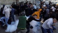 Palestinians react at tear gas that was shot by Israeli forces after Friday prayer on a street outside the East Jerusalem neighbourhood of Issawiya, February 2, 2018. Reuters/Ammar Awad