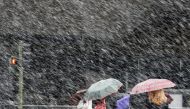 People cross a street during a heavy snowfall in Madrid, Spain, February 5, 2018. Reuters/Paul Hanna