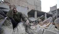 A Syrian man mourns over his destroyed home in the rebel-held besieged town of Arbin, in the eastern Ghouta region on the outskirts of the capital Damascus on February 5, 2018, following airstrikes. / AFP / ABDULMONAM EASSA