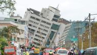 Rescue and emergency workers block off a street where a building came off its foundation, the morning after a 6.4 magnitude quake hit the eastern Taiwanese city of Hualien, on February 7, 2018. AFP / PAUL YANG