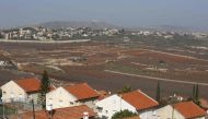 :A picture taken on February 7, 2018 from the Israeli town of Metula shows the Israeli built wall dividing it from the southern Lebanese village of Kafr Kila.  AFP / JALAA MAREY
