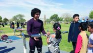 World junior champion Fares Ibrahim  offers tips to young weightlifters at the Team Qatar Village at Aspire Park yesterday.