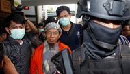 Policemen guard Islamic cleric Aman Abdurrahman during his walk to the courtroom for his trial in Jakarta, Indonesia February 15, 2018. REUTERS/Beawiharta