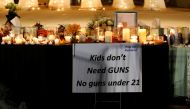 A sign is seen next to candles and tributes at a park where crosses were placed to commemorate the victims of the shooting at Marjory Stoneman Douglas High School, in Parkland, Florida, U.S., February 16, 2018. REUTERS/Carlos Garcia Rawlins