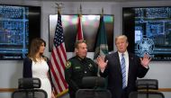 US President Donald Trump (R) and First Lady Melania Trump (L) speak with Broward County Sheriff Scott Israel (C) while visiting first responders at Broward County Sheriff's Office in Pompano Beach, Florida, on February 16, 2018, three days after a mass s