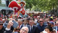 Australian Prime Minister Malcolm Turnbull takes a selfie as he walks with Victorian Premier Daniel Andrews and members of the public during a parade as part of the Chinese New Year Festival in Melbourne, Australia, February 18, 2018. AAP/David Crosling/v