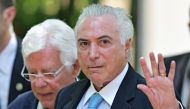 Brazil's President Michel Temer (R) waves as he arrives for a press conference at Guanabara Palace, Rio de Janeiro, on February 17, 2018. AFP