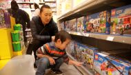 FILE PHOTO: A boy looks at Lego boxes next to his mother at a Lego store in Beijing, China January 13, 2018. REUTERS/Jason Lee/File Photo