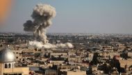 Smoke rises from buildings following bombardment on the village of Mesraba in the rebel-held besieged Eastern Ghouta region on the outskirts of the capital Damascus, on February 19, 2018. AFP / Hamza Al-Ajweh

