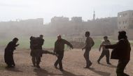 Syrians carry a wounded man who lost in his leg in air strikes on Saqba in Syria's rebel-held Eastern Ghouta area on February 20, 2018. AFP / Msallam ABDALBASET
