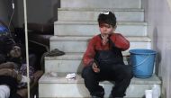 :A wounded Syrian boy waits to receive treatment at a make-shift hospital in Kafr Batna in the besieged Eastern Ghouta region on the outskirts of the capital Damascus following Syrian government bombardments on February 21, 2018.  AFP / Amer Almohibany