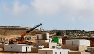 A crane lowers a caravan to the ground in Amichai, a new settlement which will house some 300 Jewish settlers evicted in February 2017 from the illegal West Bank settlement of Amona, in the Israeli occupied West Bank, February 22, 2018. Reuters/Ammar Awad