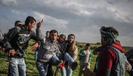 Palestinians carry a wounded man during a protest against US President Donald Trump’s announcement to recognize Jerusalem as the capital of Israel, in Shuja'iyya neighborhood of Gaza City, Gaza on February 23, 2018. (Ali Jadallah /Anadolu Agency)