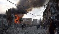 Citizens and fire fighters arrive to extinguish fire after Assad regime forces carried out an airstrike over the de-escalation zone in Douma town of Eastern Ghouta in Damascus, Syria on February 24, 2018. Mouneb Abu Taim / Anadolu Agency