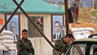 Members of the Syrian government forces stand at the Wafideen checkpoint on the outskirts of Damascus neighbouring the rebel-held Eastern Ghouta region on February 27, 2018 during an operation that would allow some of the nearly 400,000 people living in t