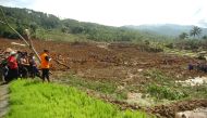 Members of a rescue team join villagers as they search for victims of a landslide triggered by a heavy rain in Brebes, Central Java province, on February 23, 2018. / AFP / - 