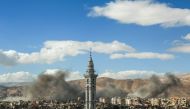 A picture taken on February 27, 2018, shows smoke plumes rising during reported regime bombardment Syrian rebel-held town of Douma, in the besieged Eastern Ghouta region on the outskirts of the capital Damascus. / AFP / HAMZA AL-AJWEH
