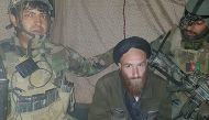 This handout picture released by the Afghan Armed Forces on February 28, 2018 shows a man (C) who identified himself as a German national after being arrested by Afghan commandos in Helmand province. AFP PHOTO / AFGHAN ARMED FORCES