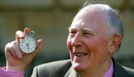 Sir Roger Bannister, who ran the first sub-four-minute mile in 1954, holds the stop watch used by Harold Abrahams to time the race during 50th anniversary celebrations at Pembroke College, Oxford, May 6, 2004. Reuters/David Bebber