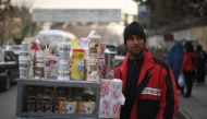File photo of Najibullah Sharyari waiting for customers at his coffee cart in Kabul, January 8, 2018.  / AFP / SHAH MARAI / 