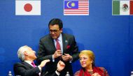 Chile's Foreign Minister Heraldo Munoz talks to Mexico's Secretary of Economy Ildefonso Guajardo Villarreal next to Chile's President Michelle Bachelet, during the signing agreement ceremony for the Trans-Pacific Partnership (TPP) trade deal, in Santiago,