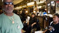 In this file photo taken on July 11, 2008 Nurney Mason (C) of Washington, DC, sits alongside customers in his son's barbershop at Mason's Hair Gallery, a barbershop and hair salon, in Washington,DC. Black barbershops are known as places to gather, sociali