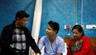 Sanam Shakya, 33, a survivor from the US-Bangla plane crash speaks with his father as his mother sits next to him while undergoing treatment at a hospital in Kathmandu, Nepal March 12, 2018. Reuters/Navesh Chitrakar