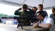 (FILES) A file photo taken and released by Presidential Photographers Division (PPD) on March 1, 2018, shows President Rodrigo Duterte firing a few rounds with a sniper rifle during the opening ceremony of the National Special Weapons and Tactics (SWAT) C