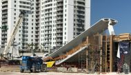 A crane is seen near a newly installed pedestrian bridge, that collapsed, over a six-lane highway in Miami, Florida on March 15, 2018, crushing a number of cars below and reportedly leaving several people dead. AFP TV / Antoni Belchi 